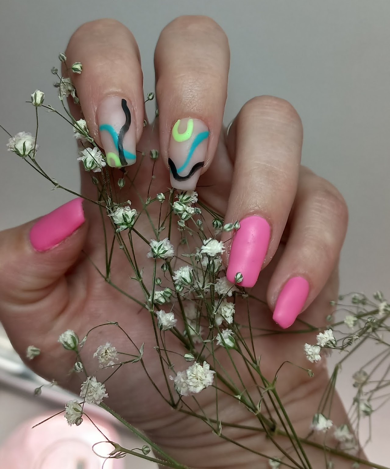 Close-up luxury shot of perfectly manicured feminine hands with elegant French manicure and soft rose pink and gold foil nail art accents, resting gracefully on a soft blush velvet textile, professional editorial beauty studio lighting, shallow depth of field, high-end salon aesthetic.