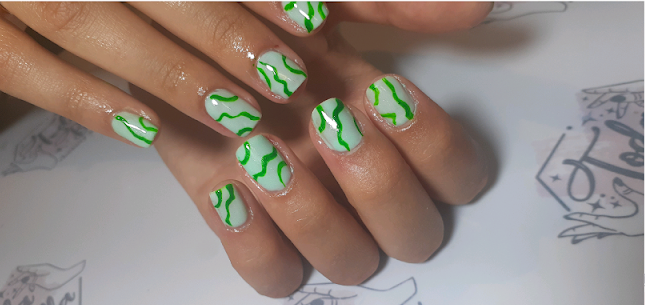 Artistic nail art close up with minimalist modern nude and soft rose tones, delicate micro-painted floral or geometric patterns, clean cuticle work, luxurious aesthetic.